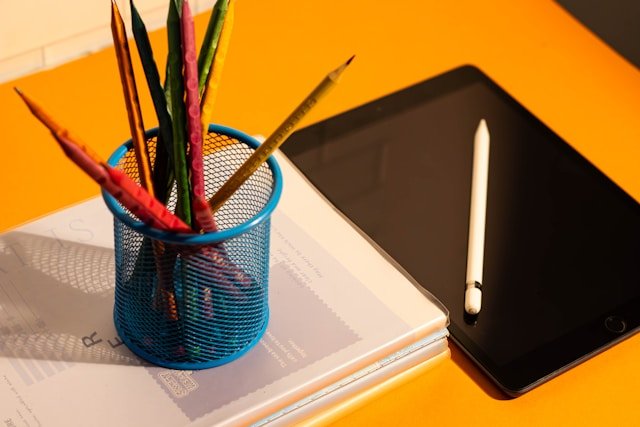 Back-to-school supplies, including different colour pencils and a tablet device