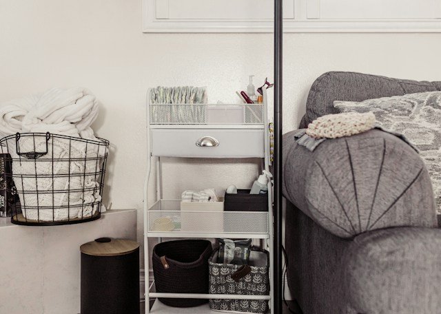 A nappy and baby product storage area next to a sofa